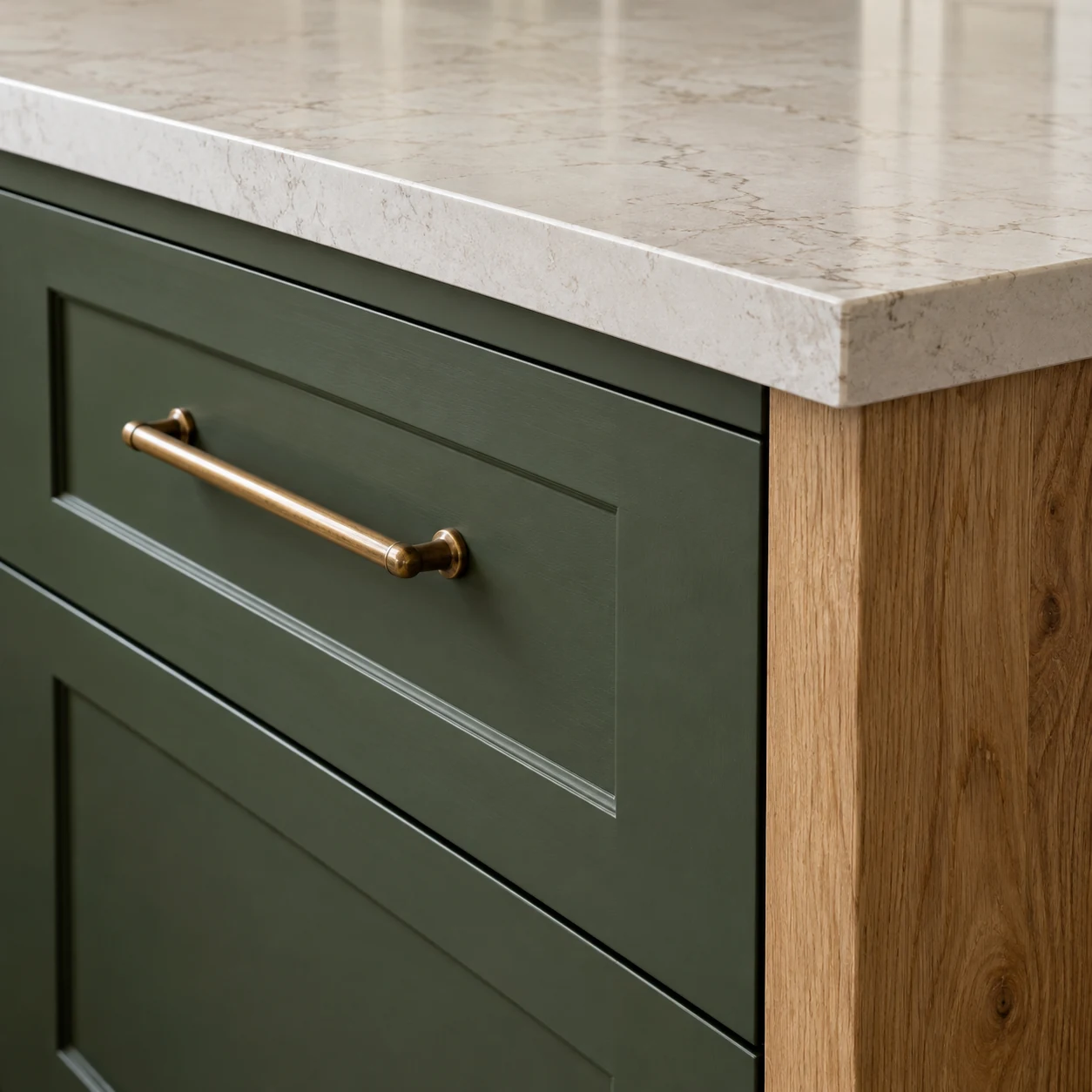 Brass drawer handle beneath a pale kitchen worktop