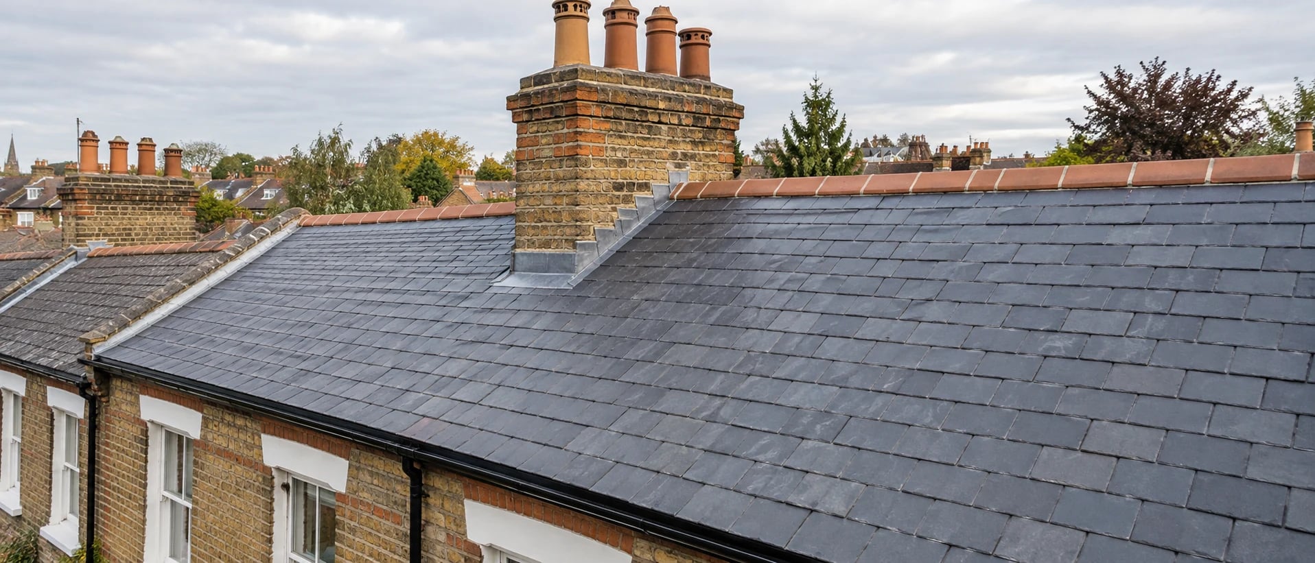 Slate roof with brick chimney, lead flashing and terracotta ridge tiles
